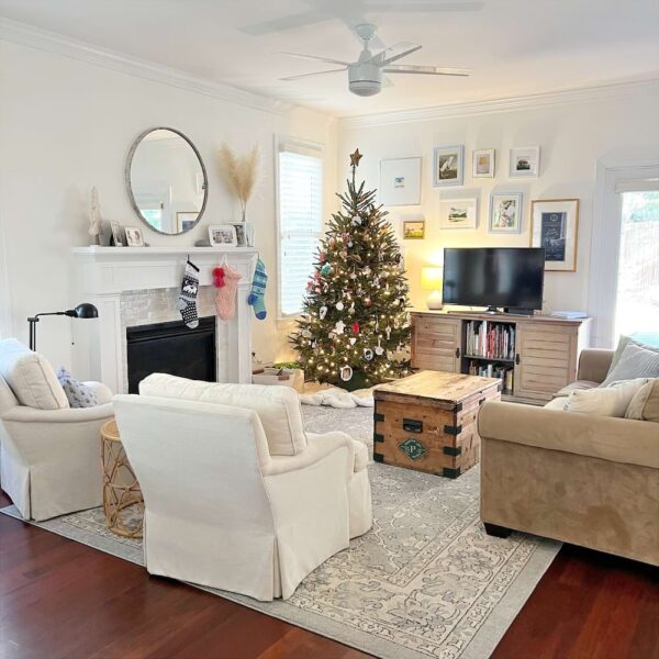 A light and bright Christmas living room with a Christmas tree and blue Oriental rug